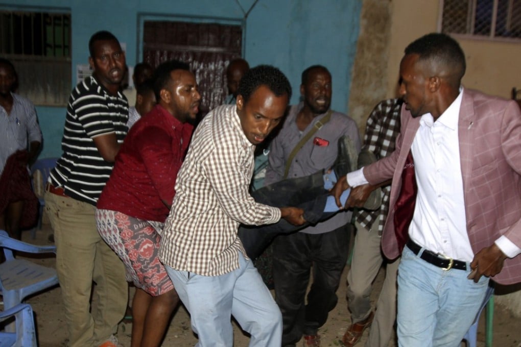 People carry a wounded man after a suspected suicide bombing in Baidoa, Somalia, on Saturday. Photo: EPA-EFE