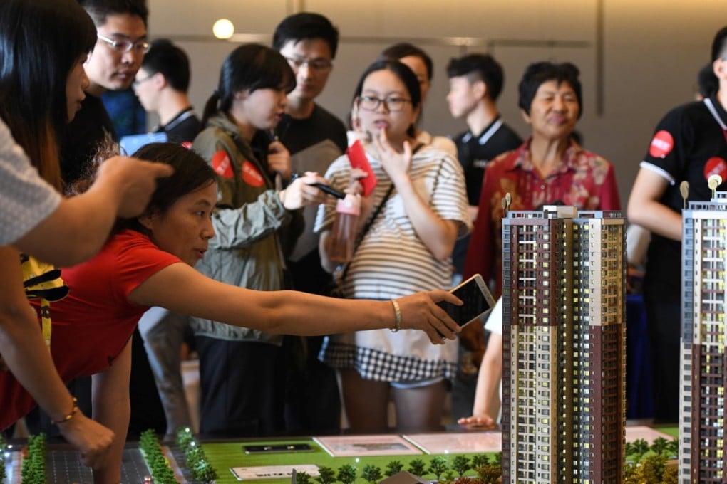 A woman points at the model of a residential compound by China Vanke during the Golden Week holiday in Dongguan. Photo: Reuters