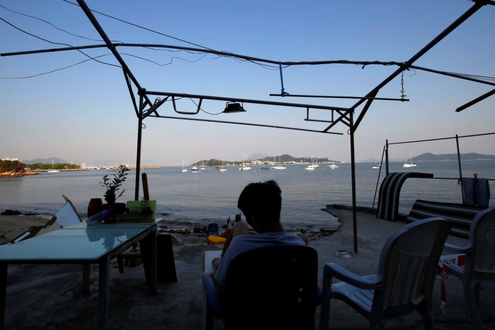 A resident of Lantau’s Nim Shue Wan village sits facing the sea where an artificial island will be built if government plans are approved. Photo: Reuters