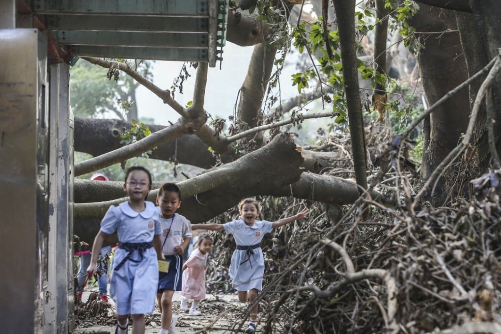 Children walk under collapsed trees along Tin Ping Road in Sheung Shui after Typhoon Mangkhut. Photo: Sam Tsang