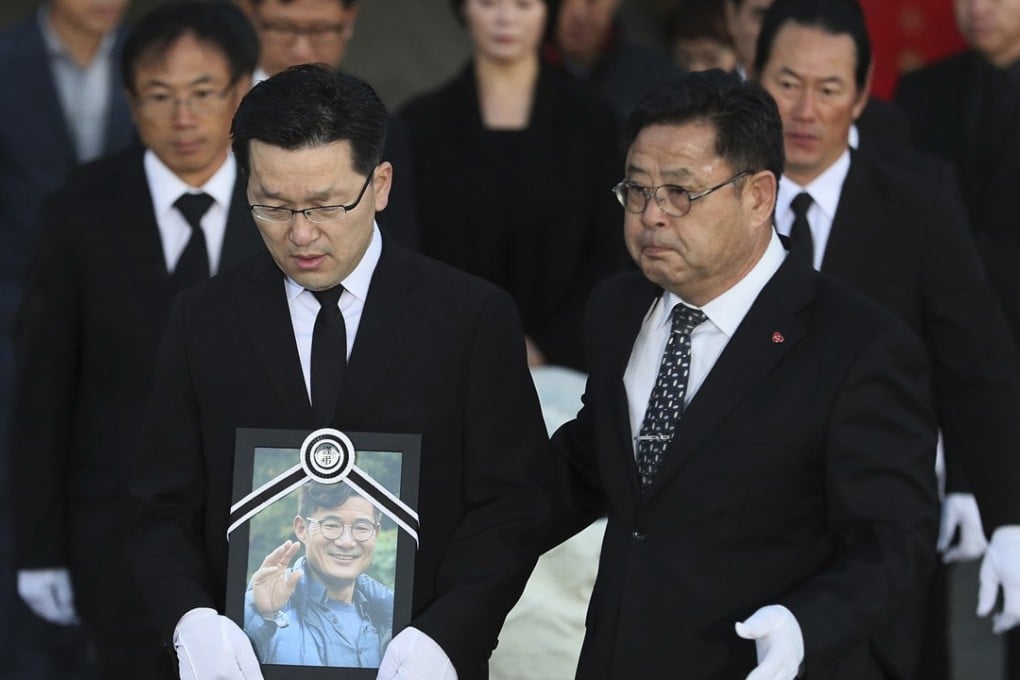 Relatives and friends of the late mountain climber Kim Chang-ho carry his portrait and the casket containing his body. Photo: AP