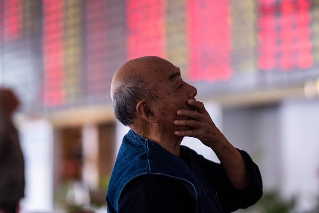 An investor looks at an electronic board showing stock information at a brokerage house in Shanghai on October 15. Photo: AFP