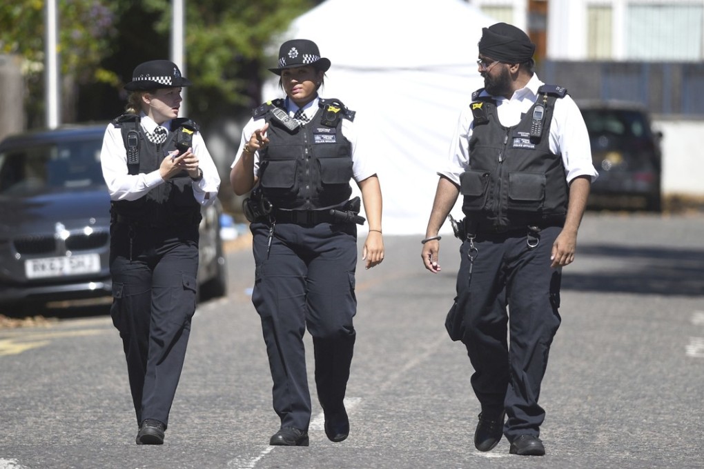 File photo of police officers walking near the scene of a fatal stabbing in Camberwell, south London. Photo: AP
