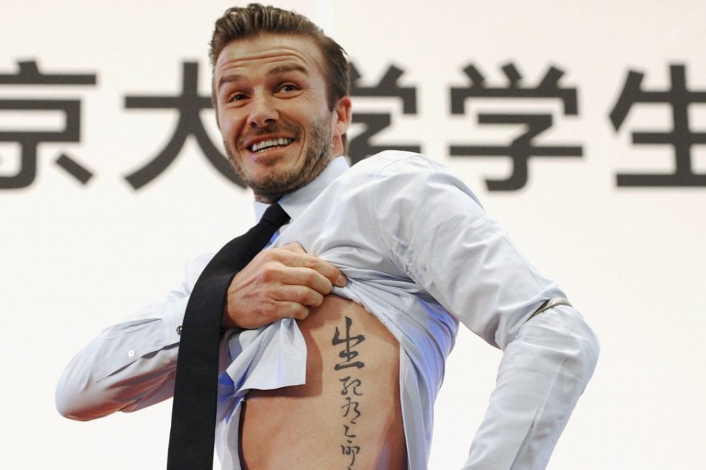 David Beckham shows his tattoo during a visit to Beijing in 2013. The tattoo in Chinese characters reads, "Life and death are determined by fate, rank and riches decreed by Heaven." Photo: Reuters