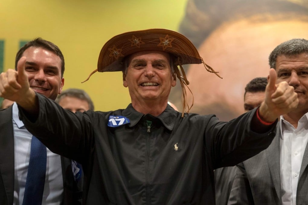 Brazil's right-wing presidential candidate for the Social Liberal Party, Jair Bolsonaro, gestures flanked by his son and Rio de Janeiro's elected Senator, Flavio Bolsonaro and the president of the party, Gustavo Bebianno. Photo: AFP