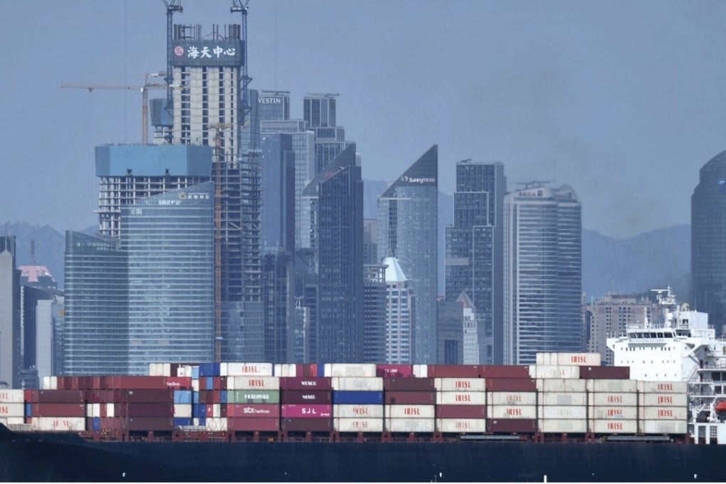 A ship laden with containers sails past the Qingdao skyline in east China’s Shandong province. Photo: AP