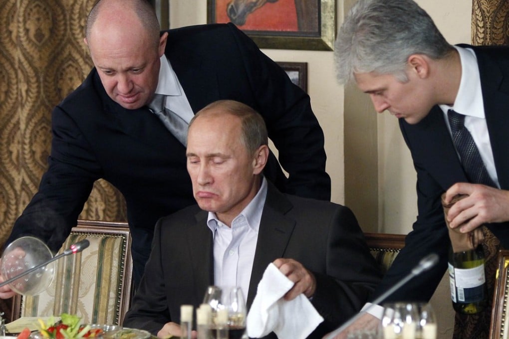 In this 2011 file photo, businessman Yevgeniy Prigozhin, left, serves food to Russian Prime Minister Vladimir Putin, centre, during dinner at Prigozhin's restaurant outside Moscow. Photo: AP