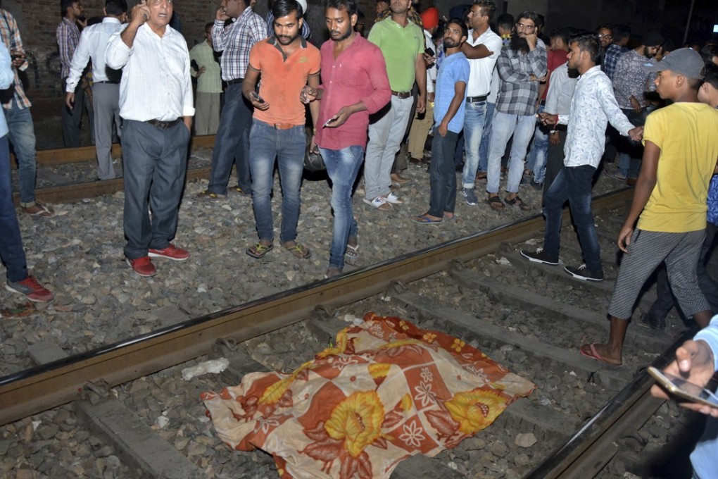 The body of a victim of a train accident lies covered in cloth on a railway track in Amritsar, India, on Friday. Photo: AP