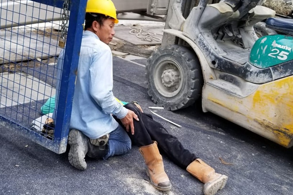 A worker supporting one of two workers reportedly injured at a construction site on Muk Ning Street opposite the One Kai Tak property development in Kai Tak. Photo: Facebook