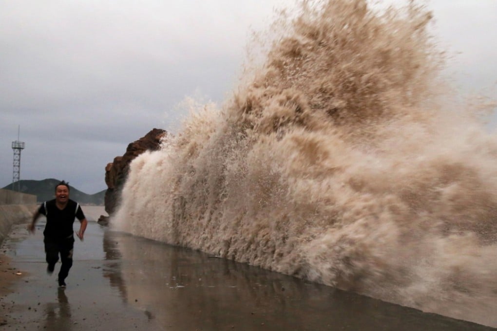 A man runs next to huge waves breaking on the waterfront, as the Typhoon Kong-rey approaches in Taizhou, Zhejiang province, on October 4, 2018. Photo: Reuters