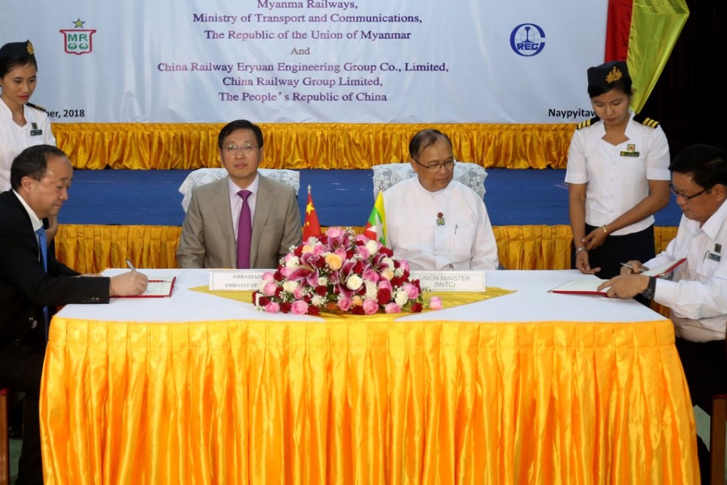 Zhu Ying (left), of China Railway Eryuan Engineering Group, and Thurein Win (right), of Myanmar Railways, sign a memorandum of understanding on Monday. Photo: Xinhua