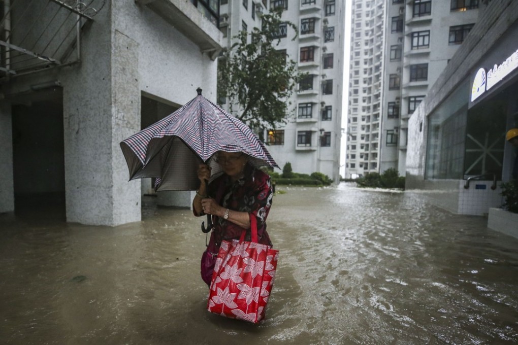 An elderly lady walks along a flooded footpath in Heng Fa Chuen as Typhoon Mangkhut approaches. Photo: Sam Tsang