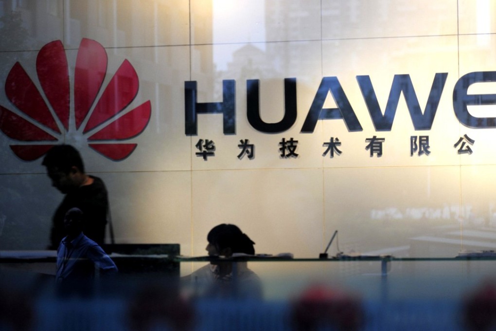 Staff and visitors walk pass the lobby at the Huawei office in Wuhan, central China's Hubei province on October 8, 2012. Photo: AFP