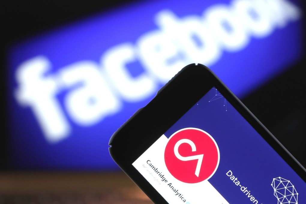 File phot of the Cambridge Analytica logo on a phone screen in front of Facebook’s logo on a computer screen. Photo: Bloomberg