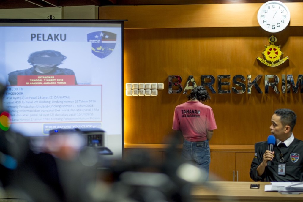 Indonesian cybercrime police display a suspect accused of spreading fake news and online hate speech. Photo: AFP