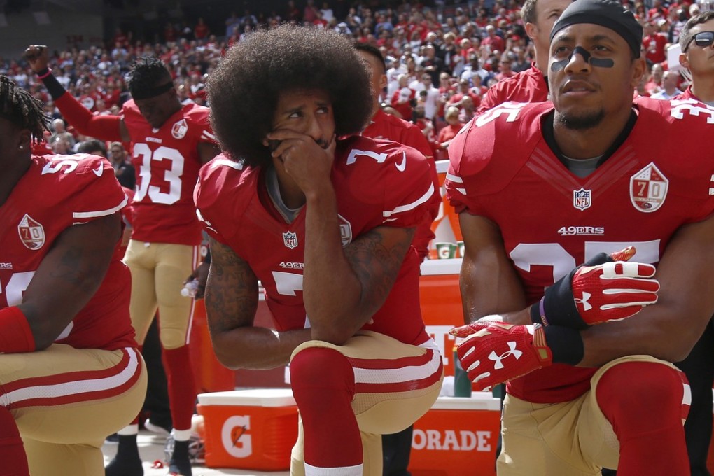 Former San Francisco 49ers quarterback Colin Kaepernick (centre) flanked by Eli Harold (left) and Eric Reid during the national anthem in October 2016. Photo: TNS