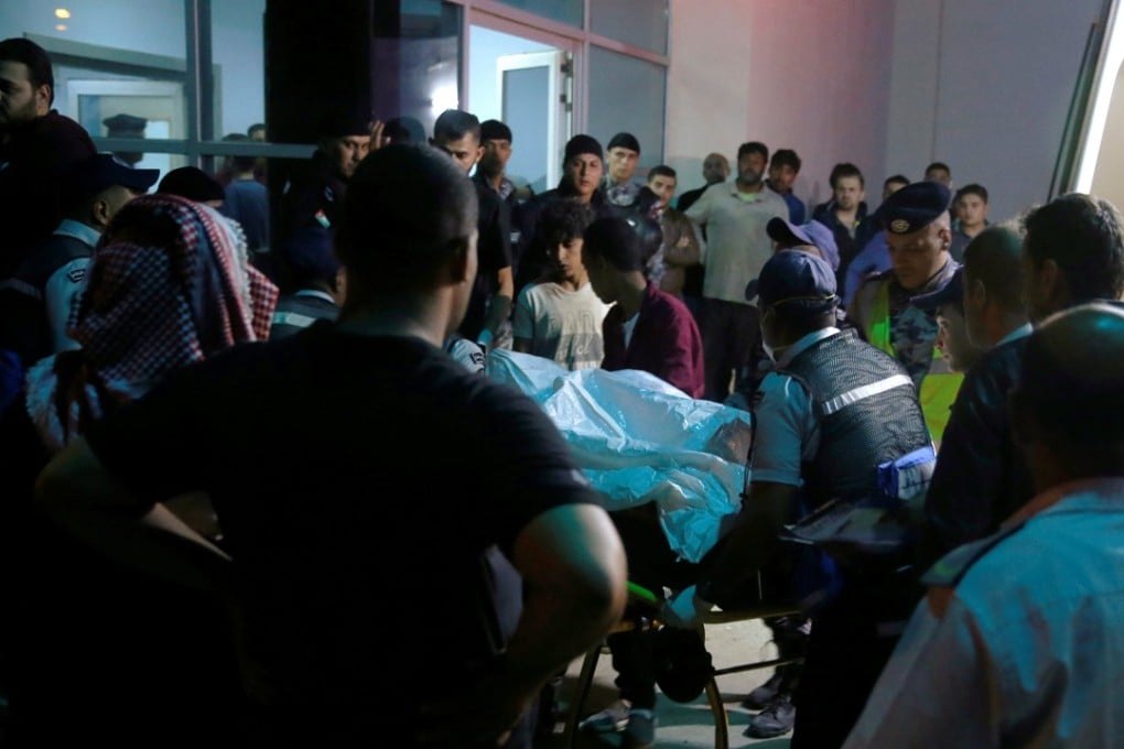 A victim is rushed to a hospital in Jordan near the Dead Sea, as residents and relatives of flood victims gather outside on Thursday. Photo: Reuters