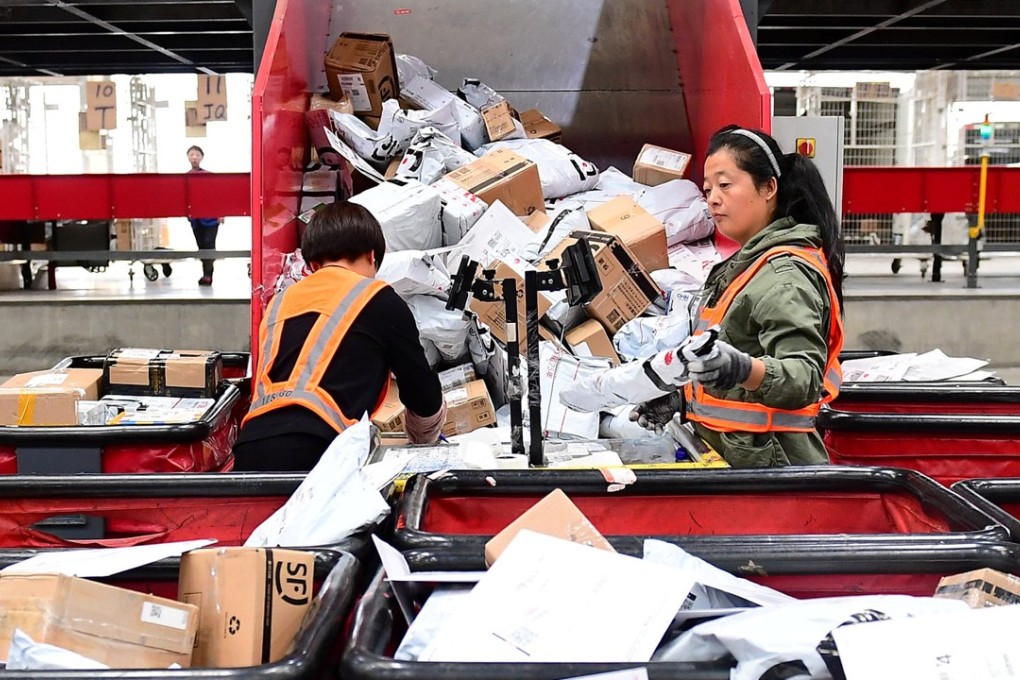 Workers sort parcels at an online shopping distribution centre in China. Photo: Reuters