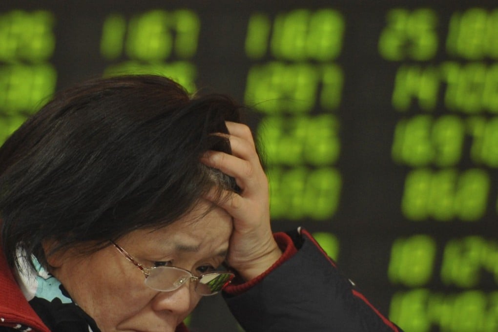 A stock brokerage customer at a trading hall in Fuyang in central China's Anhui province on January 11, 2016. Contrary to global conventions, China represents losses and declines in green, so a wall of greenlit figures denotes a falling market. Photo: Chinatopix via AP