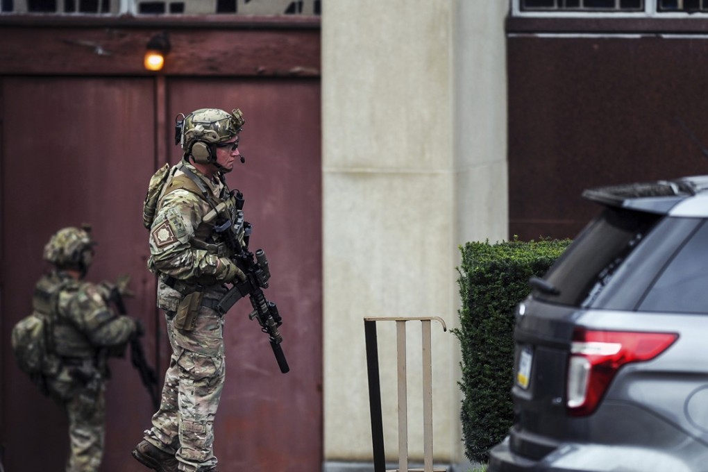Law enforcement officers check possible entrances to The Tree of Life synagogue where multiple people were killed. Photo: AP