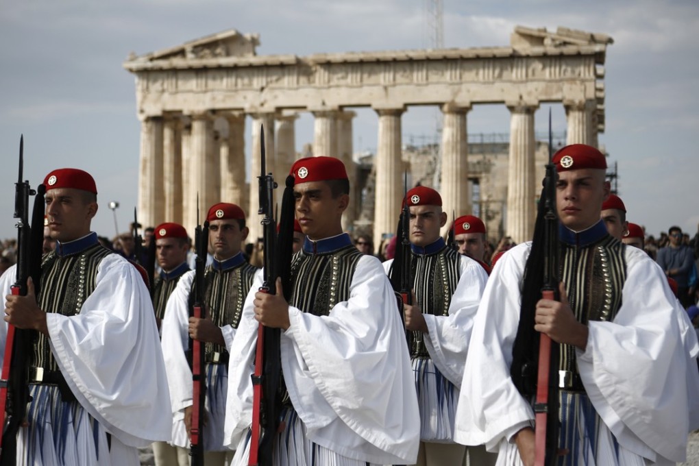 Presidential guards present arms in front of the Parthenon temple during the ceremony for the annual anniversary of the liberation of Athens from Nazi occupation, at the Acropolis Hill, in Athens. Photo: EPA