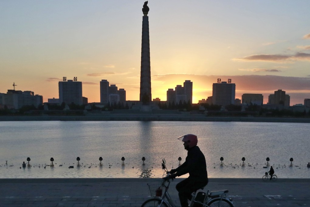 In Pyongyang, a man rides his electric bike near the Tower of the Juche Idea. Photo: AP