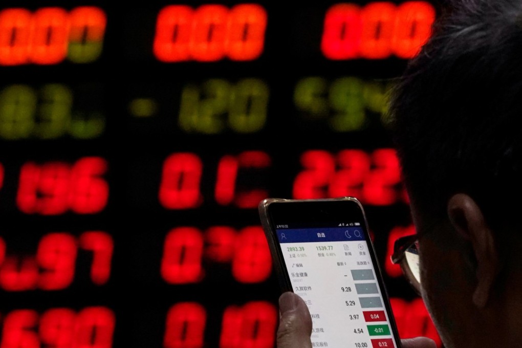 An investor checks stock information on a mobile phone at a brokerage house in Shanghai on June 20, 2018. Photo: Aly Song