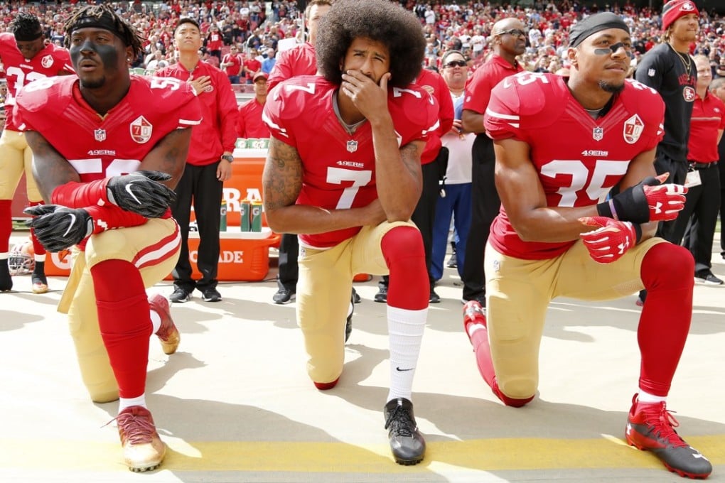 San Francisco 49ers quarterback Colin Kaepernick (centre), takes a knee with teammates Eli Harold (left), and Eric Reid (right) during the US national anthem before the NFL game against the Dallas Cowboys in October, 2016. Photo: EPA-EFE