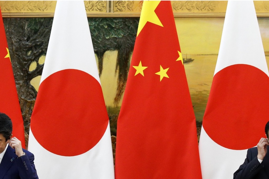 Japanese Prime Minister Shinzo Abe (left) and Chinese Premier Li Keqiang put on their earpieces during a joint press conference at the Great Hall of the People in Beijing on October 26. Abe was the first Japanese prime minister to visit China since 2011. Photo: AP
