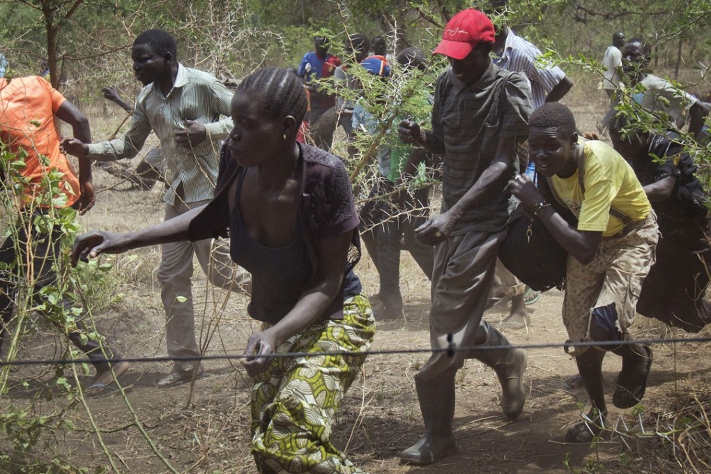 file photo of South Sudanese refugees running towards a supply distribution point in Uganda. Photo: AP