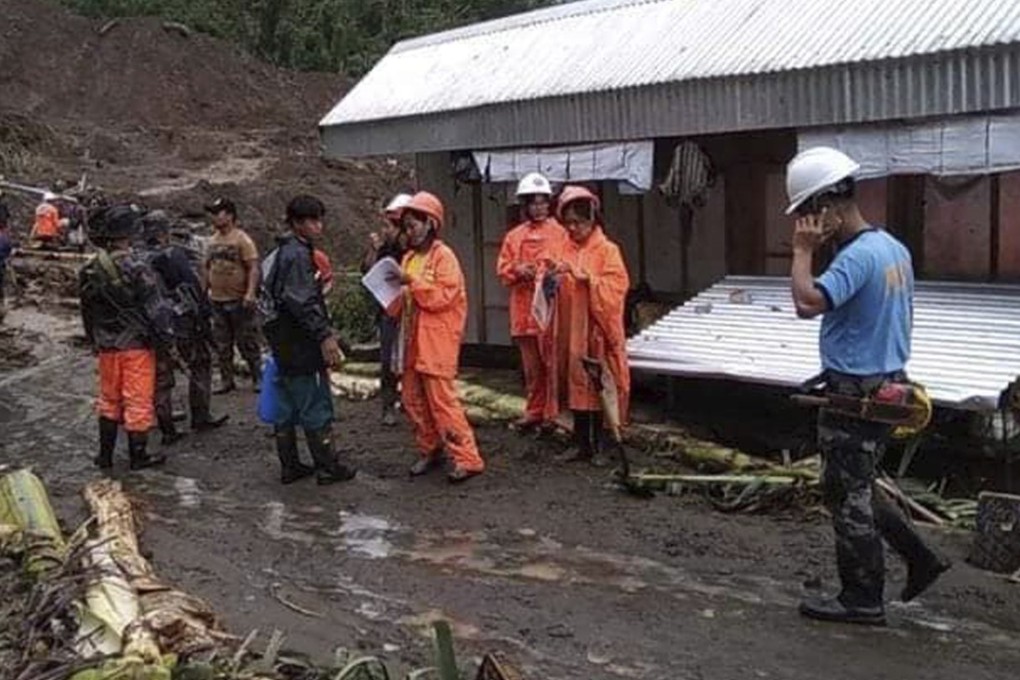 Rescuers prepare to dig through the earth to search for survivors after a massive landslide, set off by Typhoon Yutu. Photo: AP