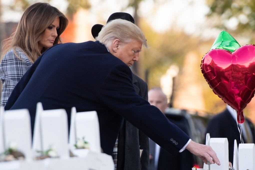 US President Donald Trump and First Lady Melania Trump place stones and flowers on a memorial on Tuesday as they pay their respects at the Tree of Life Synagogue following Saturday's shooting in Pittsburgh. Photo: Agence France-Presse