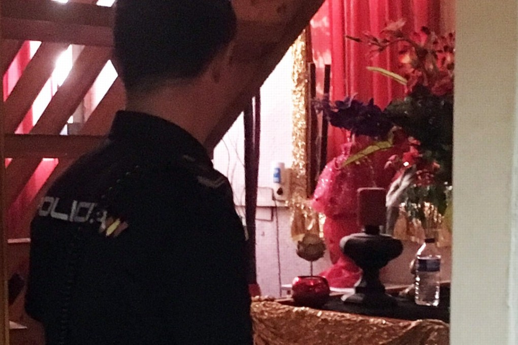 A police officer looking at a Santeria altar found during a police search of a flat in Murcia that was used by a sex trafficking ring. Photo: Spanish National Police handout via AFP