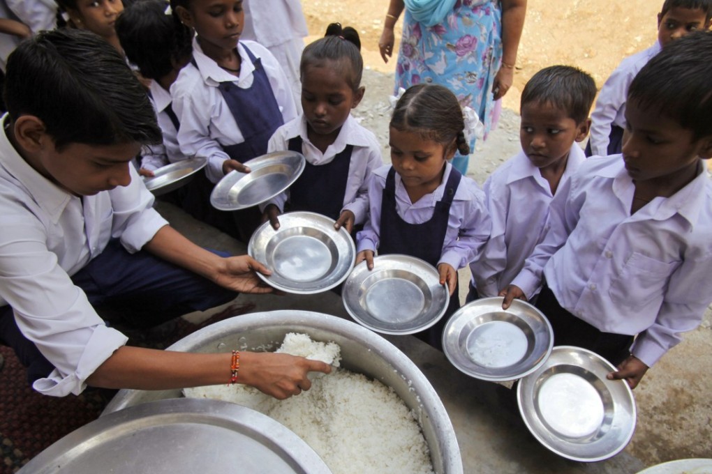 Indian schoolchildren receive a free midday meal at a government school. Photo: AP