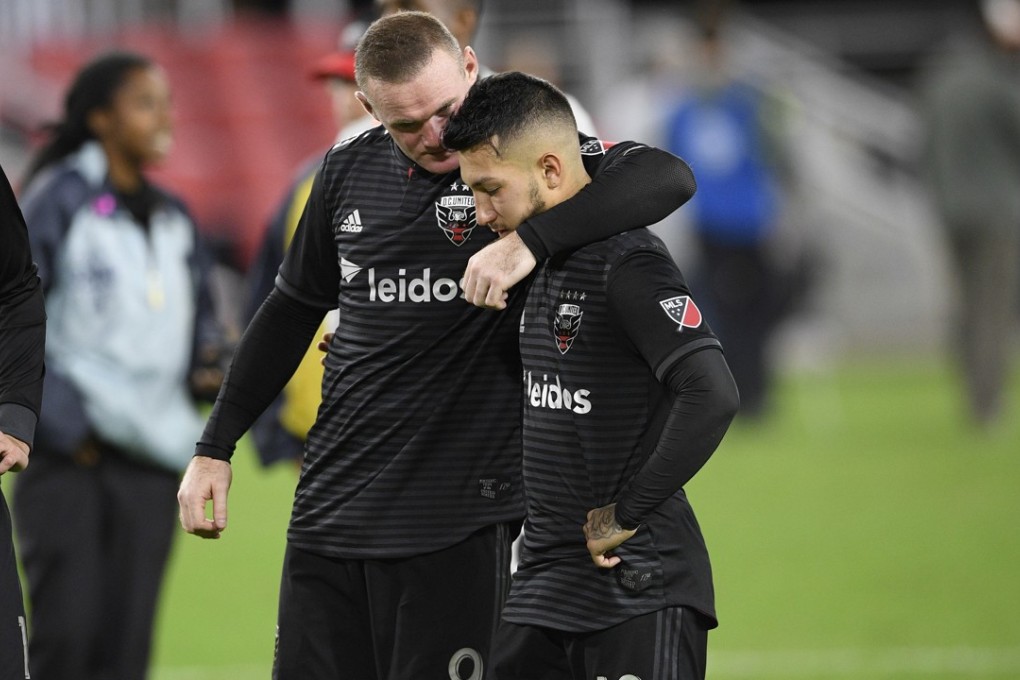 D.C. United forward Wayne Rooney (left) consoles midfielder Luciano Acosta after he missed the decisive penalty kick against Columbus Crew. Photo: AP