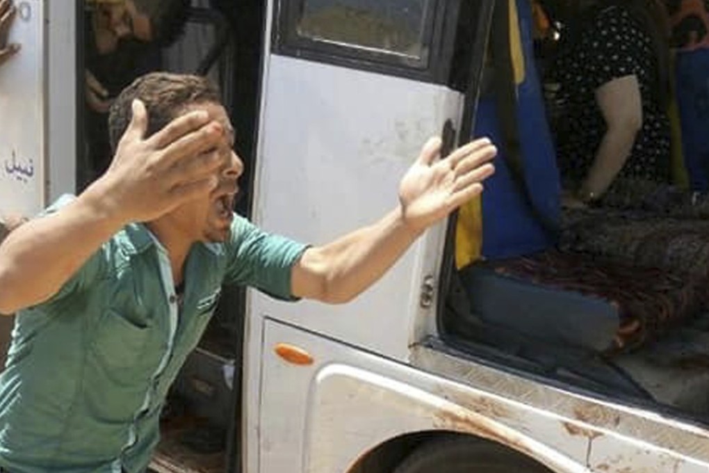 A man screams beside a bus carrying Coptic Christians which came under attack outside Cairo on Friday. Photo: AP