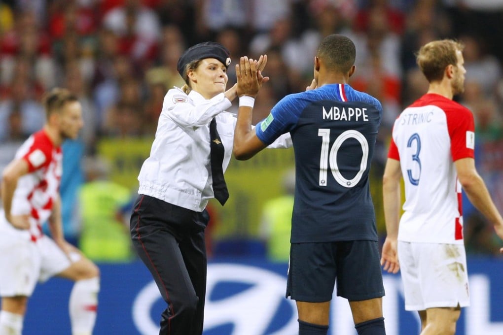 A member of Pussy Riot high-fives French player Kylian Mbappé during a pitch invasion in the second half of the World Cup final between France and Croatia in Moscow in July. Two of the four who took part are in Hong Kong. Photo: Kyodo