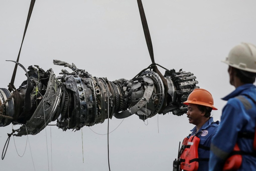 Rescue team members lifting up an turbine engine of Lion Air flight JT610. Photo: Reuters