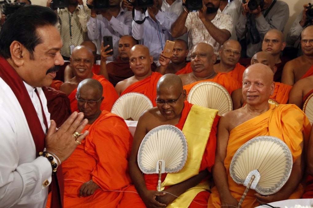 Former Sri Lankan President Mahinda Rajapaksa salutes and greets the Buddhist clergy prior to assuming duties as the new Prime Minister in Colombo, Sri Lanka. Photo: EPA