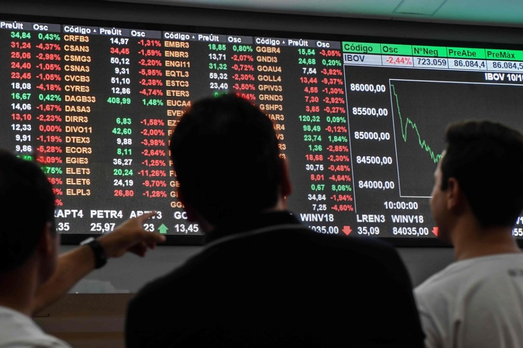 Visitors look at an electronic board at the B3 stock exchange in Sao Paulo. The main Brazilian stock benchmark is up 15.7 per cent for the year. Photo: AFP