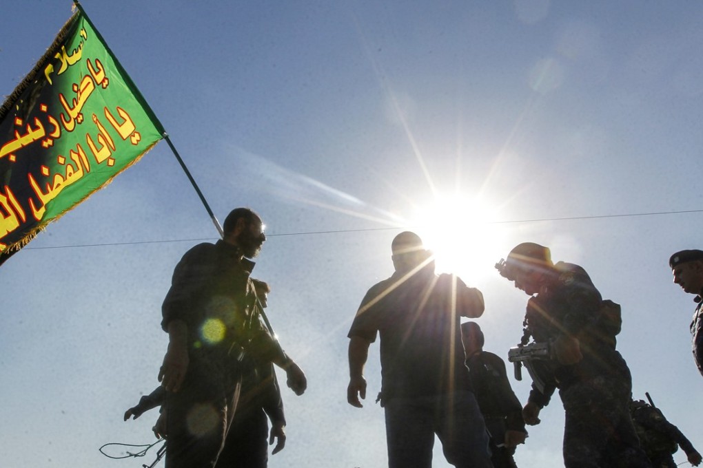 Iraqi policemen stand on guard as they secure Shiite Muslim pilgrims walking on the outskirts of the Iraqi capital Baghdad towards the central Iraqi shrine city of Karbala. Photo: AFP