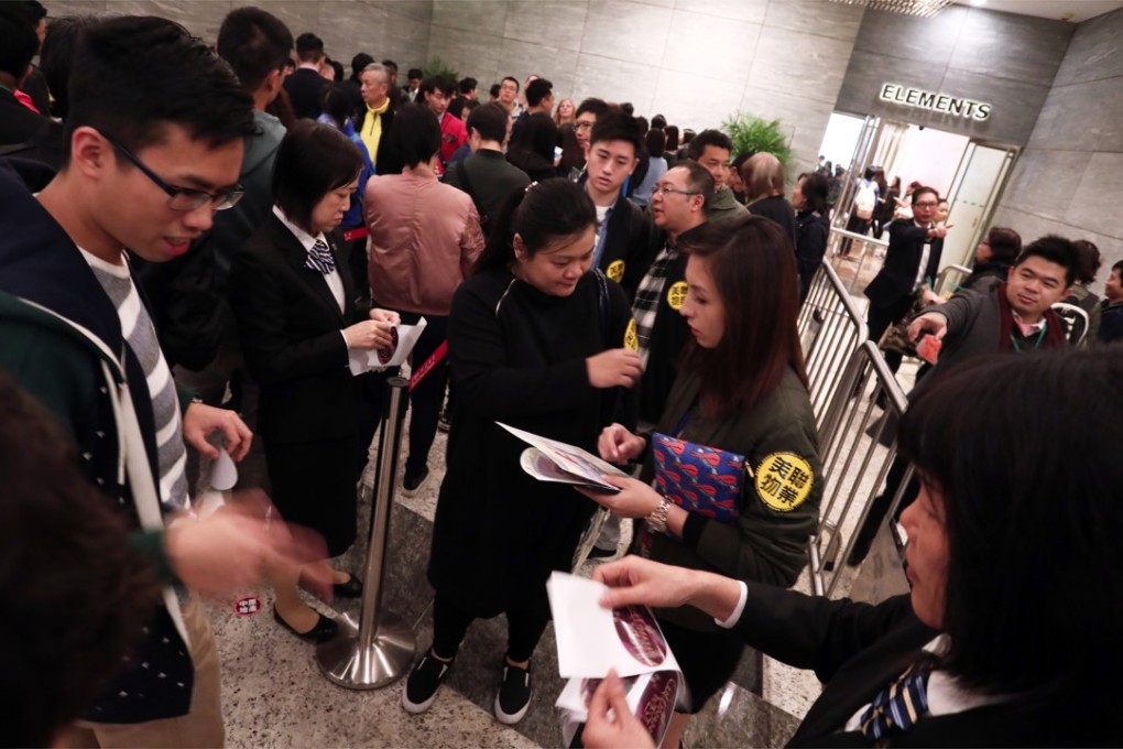 Property agents solicit prospective homebuyers at the sale office of a new development in Hong Kong. Photo: Jonathan Wong