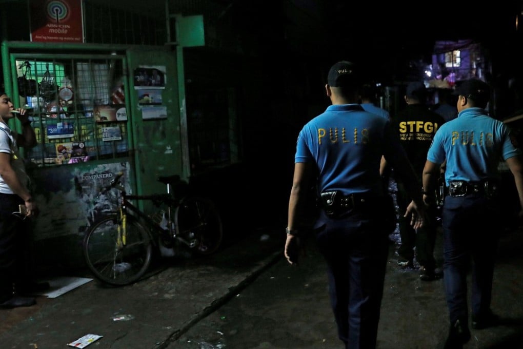 Policemen patrol a dimly lit alley in Metro Manila. Photo: Reuters