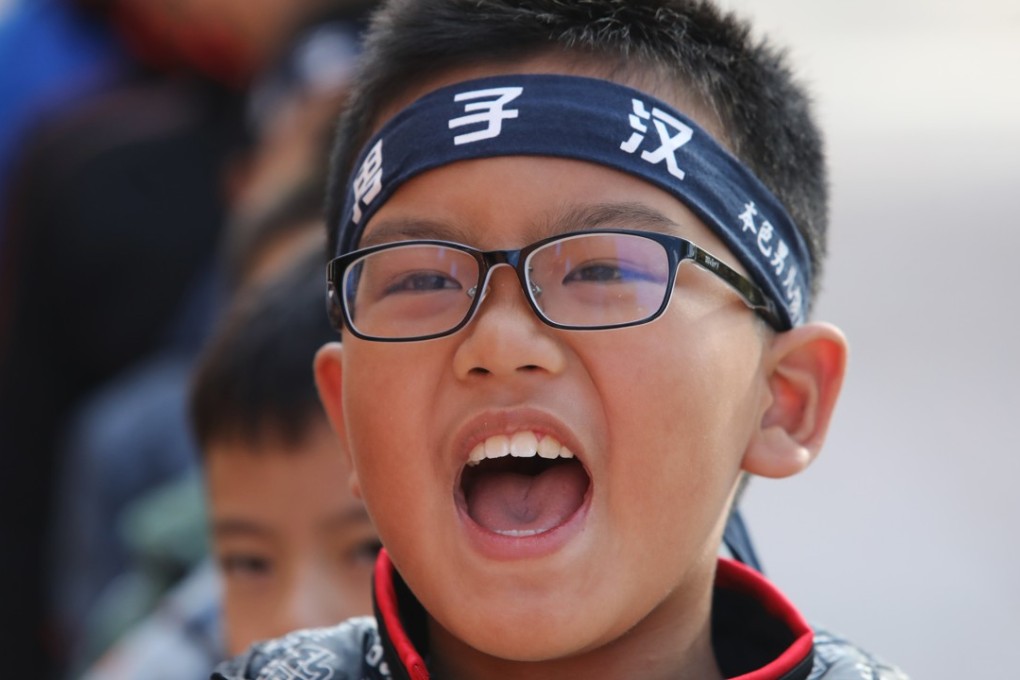 A boy wears a headband that says “real men” as he takes part in a weekend training camp in Beijing organised by Boys’ Club founder Tang Haiyan. Photo: Simon Song
