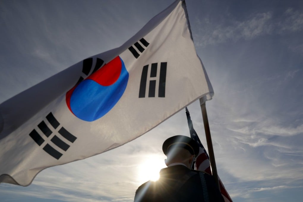 A member of the Honour Guard carries the South Korean flag. Photo: AP