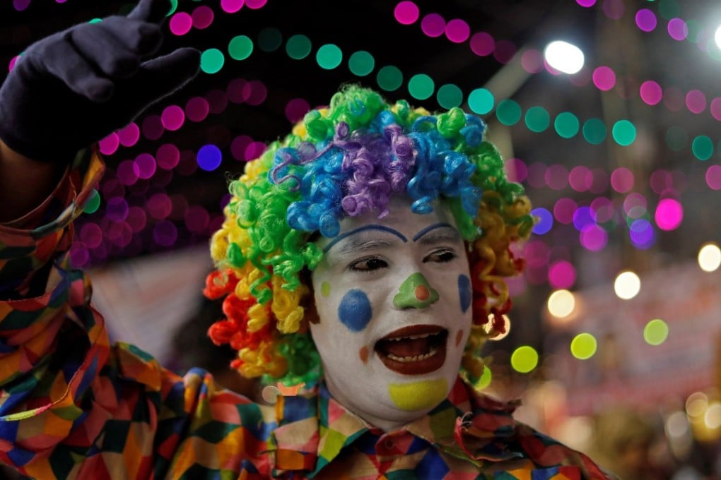 A man in a clown costume attracts customers to a stall in a market on the eve of Diwali in New Delhi, India. Photo: Reuters/Anushree Fadnavis