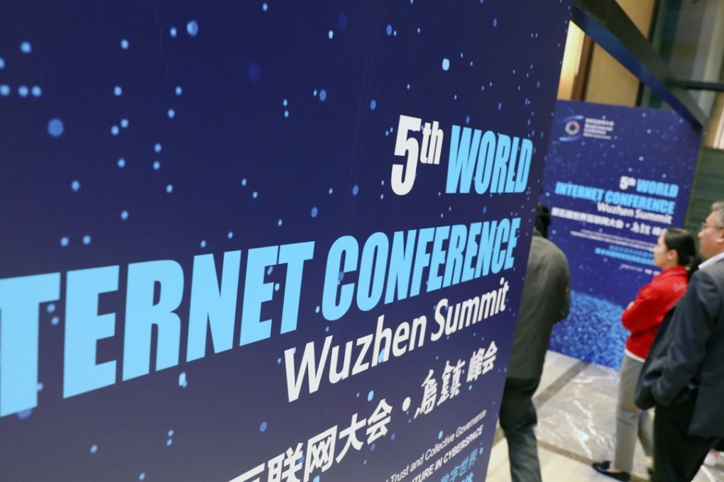 People walk past a billboard of the 5th World Internet Conference at Wuzhen, Jiaxing city, east China's Zhejiang province, on November 2018. Photo: SCMP