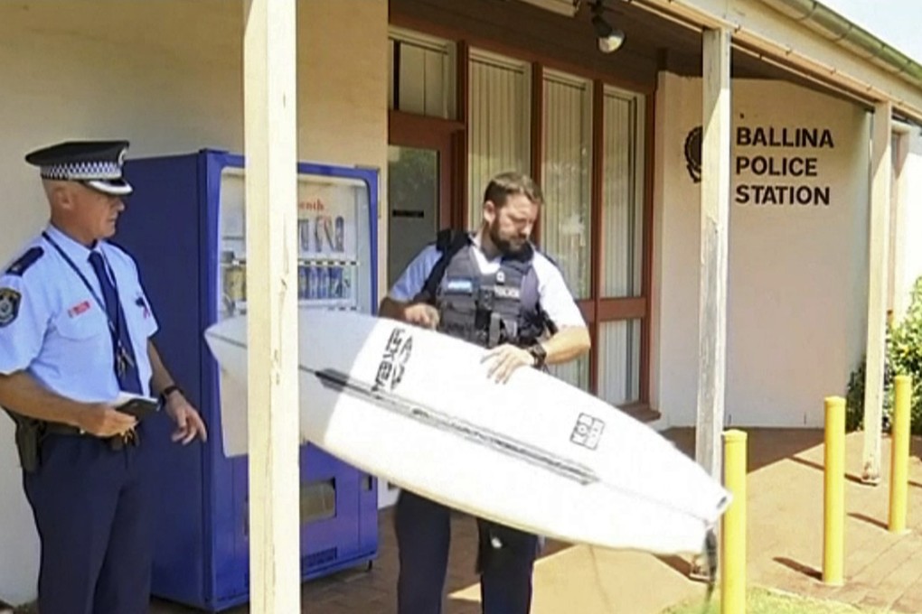 A police officer holds the surfboard that was used to fend off the shark. Photo: ABC/AP