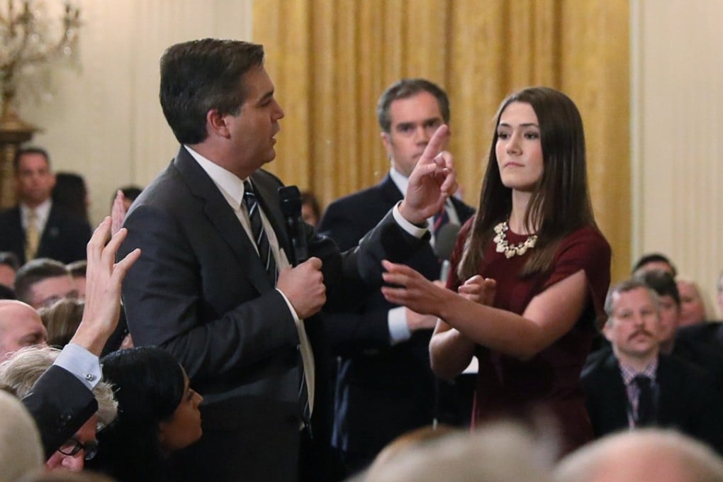 A White House intern reaches for the microphone held by CNN correspondent Jim Acosta as he questions US President Donald Trump during a news conference at the White House in Washington on Wednesday. Photo: Reuters