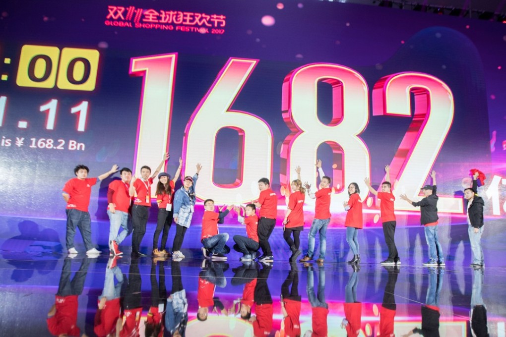 Staff pose for photos in front of a screen at a gala event in Shanghai showing total sales of over 168 billion yuan on Singles’ Day 2017. Photo: AFP
